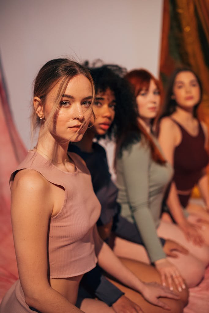 A diverse group of women confidently posing together in a stylish studio shoot, symbolizing empowerment and unity.